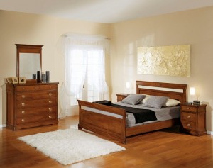 Klasična spavaća soba u boji oraha, izrađena od masivnog drva. Noćni ormarić sa tri ladice, klasični krevet za dvije osobe, komoda sa pet ladica i ogledalom u kompletu, su elementi koji čine komplet ove klasične sobe. Može se naručiti u drugim bojama drva.
