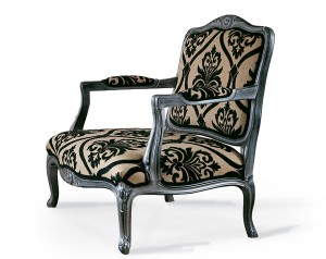 Klasična fotelja sa drvenim okvirom u sivoj boji, presvučena u materijal sa cvijetnim uzorkom u bež i crnoj boji. Može se naručiti u drugim bojama drva i drugim materijalima.