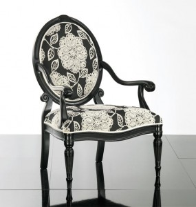 Klasična drvena stolica sa rukonaslonima, lakirana u crnu boju, sjedište i leđa u tkanini. Može se naručiti u drugim bojama drva i bojama tkanina.