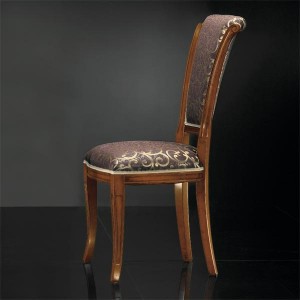 Klasična drvena stolica u boji oraha, sjedište i leđa u tkanini. Može se naručiti od rugih materijala i boja drva.