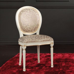 Klasična drvena stolica, lakirana u bijelu boju sa patinom i detaljima tapkanim sa zlatnim listićima. Sjedište i leđa u tkanini. Stolica se može naručiti u različitim drugim bojama drva i različitim takaninama.
