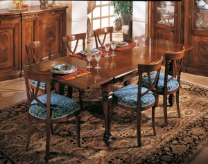 Klasična blagavaona izrađena od masivnog drva u boji oraha. Klasični stol sa pločom u intarziji 160x100 cm. (otvoreni 240x100). U kompletu su klasične stolice sa sjedištem u tkanini. Može se naručiti u drugim bojama drva i drugim tkaninama.